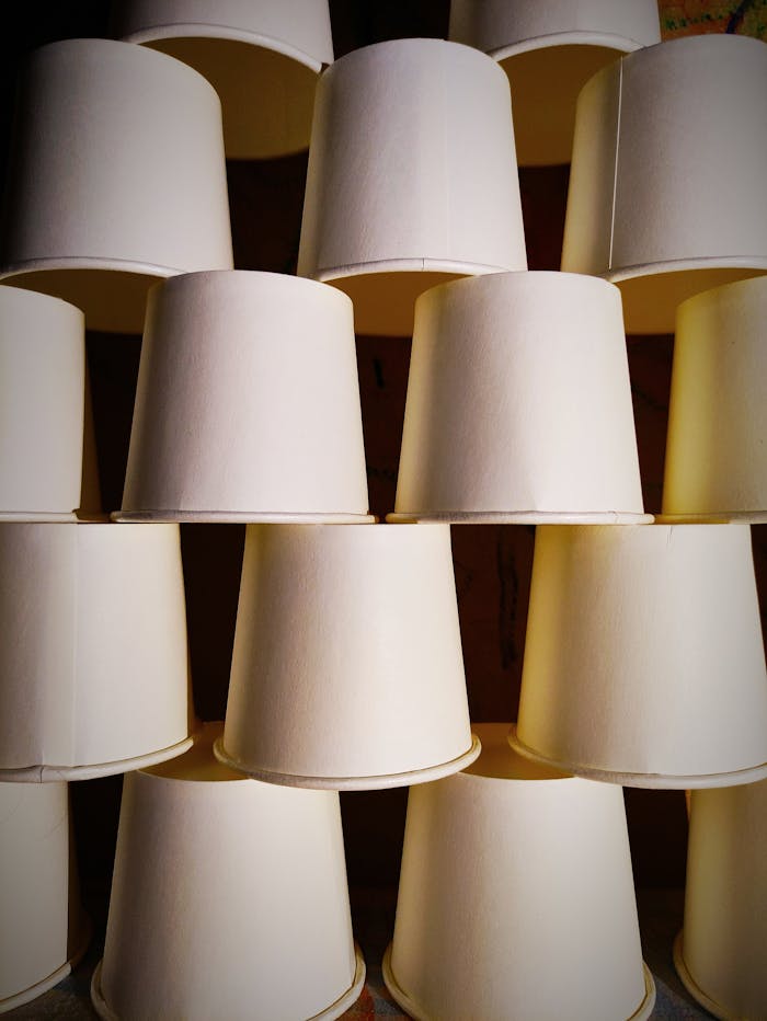 A close-up view of stacked disposable paper cups in a repetitive pattern.